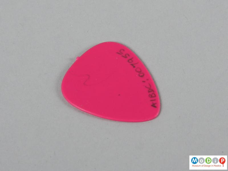 Rear view of a guitar pick showing the plain back.