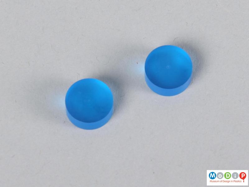 Top view of two blue contact lens buttons showing the surface.