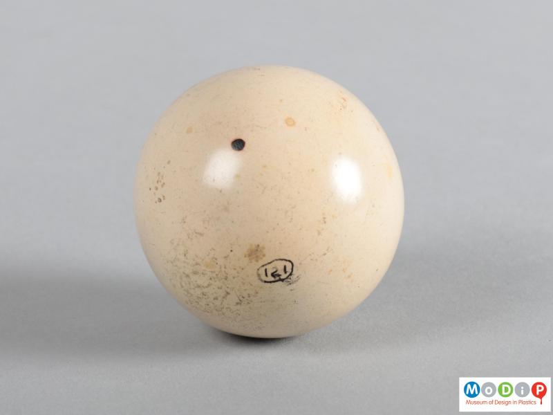 Side view of a billiard ball showing the pitted surface.