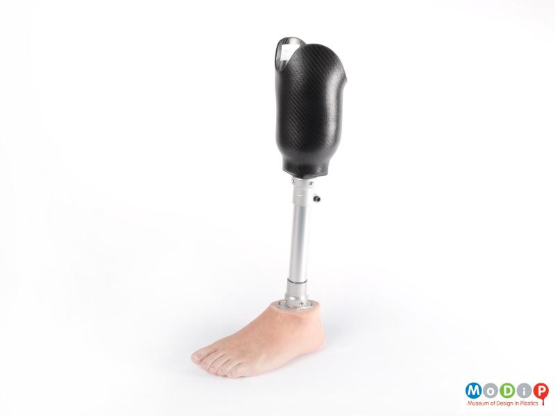 Side view of a prosthetic leg showing the outer edge of the carbon fibre composite cup and silicone foot.