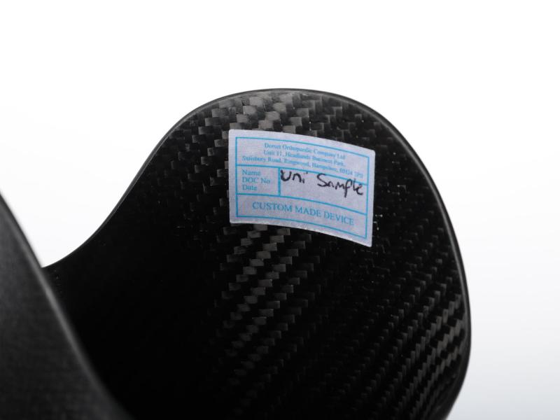 Close view of a prosthetic leg showing the label of the carbon fibre composite cup.