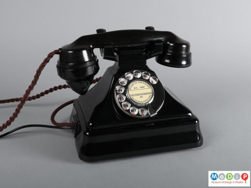 Front view of a telephone showing the dial and handset.