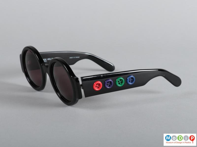 Side view of a pair of sunglasses showing the buttons on the arms.