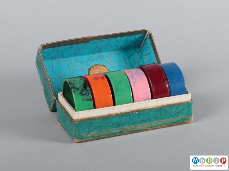 Front view of a box of napkin rings showing the open box.