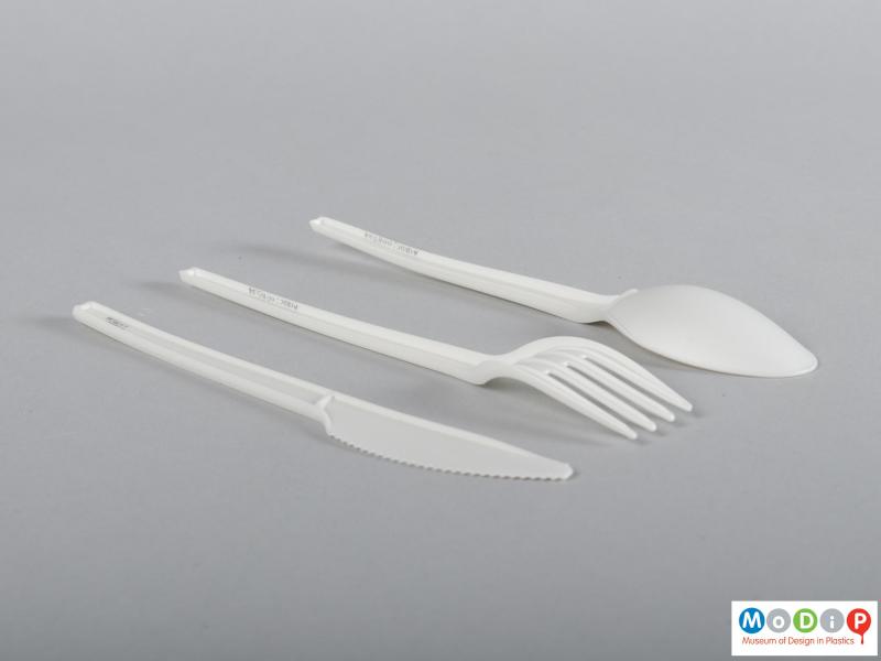 Side view of a cutlery set showing the curve of the fork head.