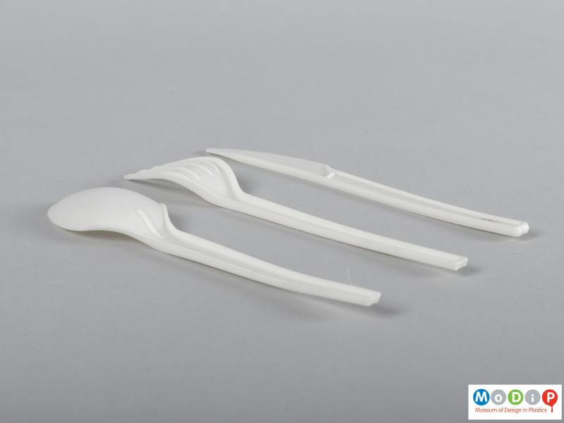 Side view of a cutlery set showing the injection moulding gates at the end of the handles.