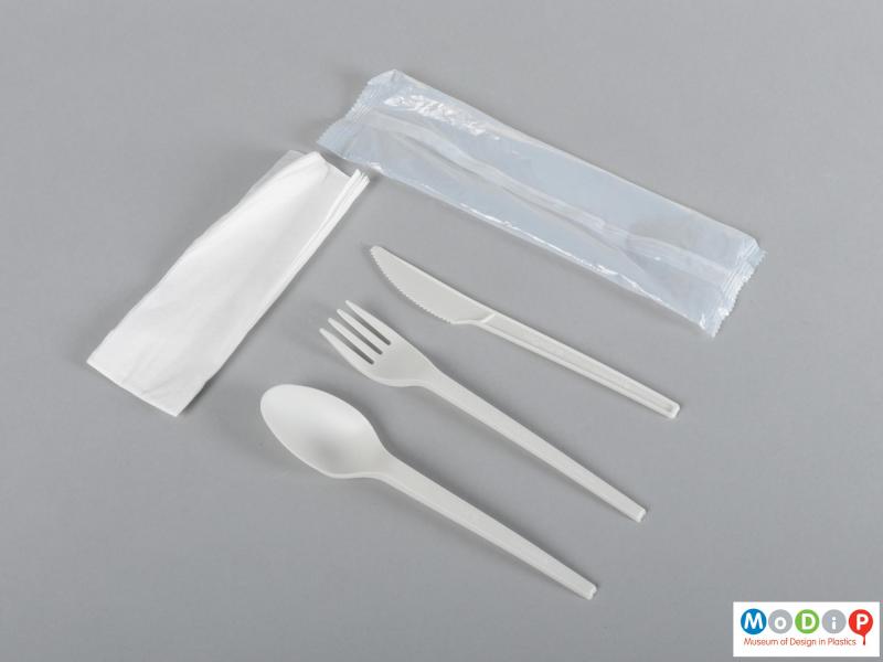 Top view of a cutlery set showing the paper napkin and plastic wrapper.
