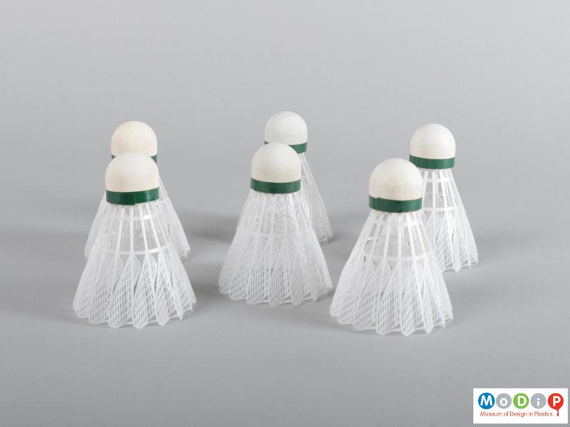 Side view of a shuttlecock showing all 6 with the feathered designed skirts.