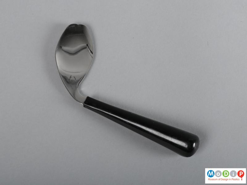 Side view of a spoon / fork showing the shaped handle and the double-pointed bowl.