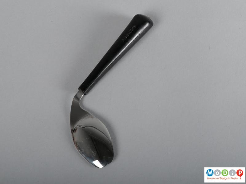 Side view of a spoon / fork showing the shaped handle and the double-pointed bowl.