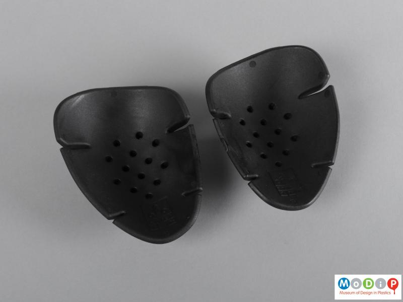 Underside view of a set of protective pads showing the ventilation holes in the shoulder pads.
