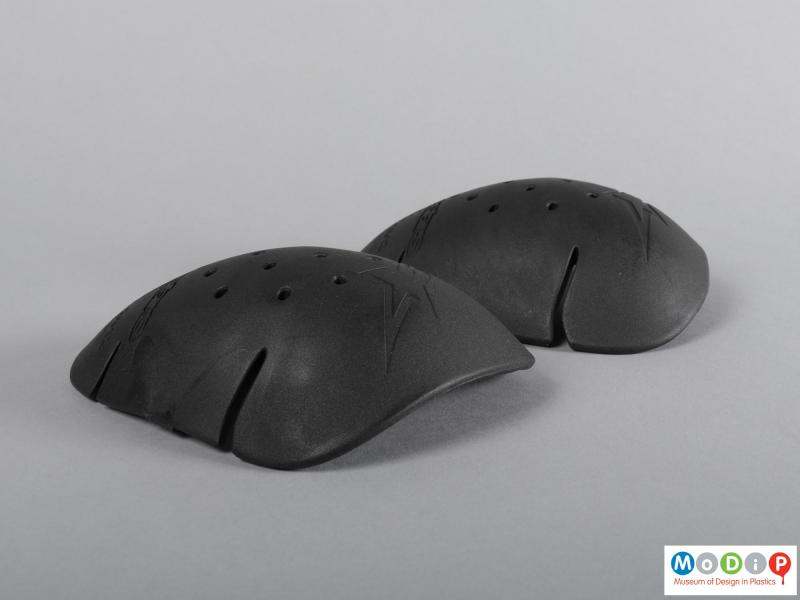 Side view of a set of protective pads showing the curved profile of the shoulder pads.