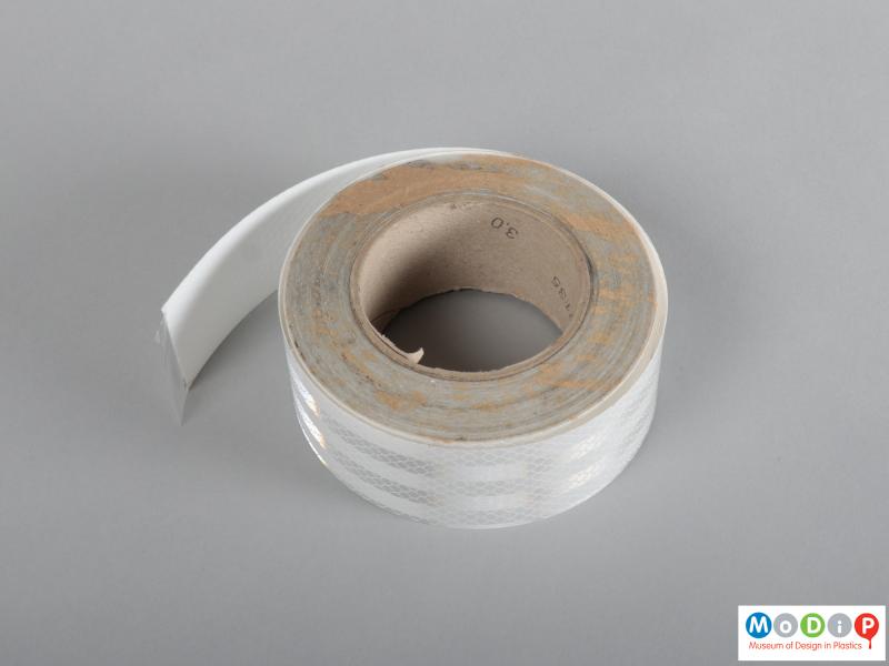 Underside view of a roll of tape showing the thickness of the tape.
