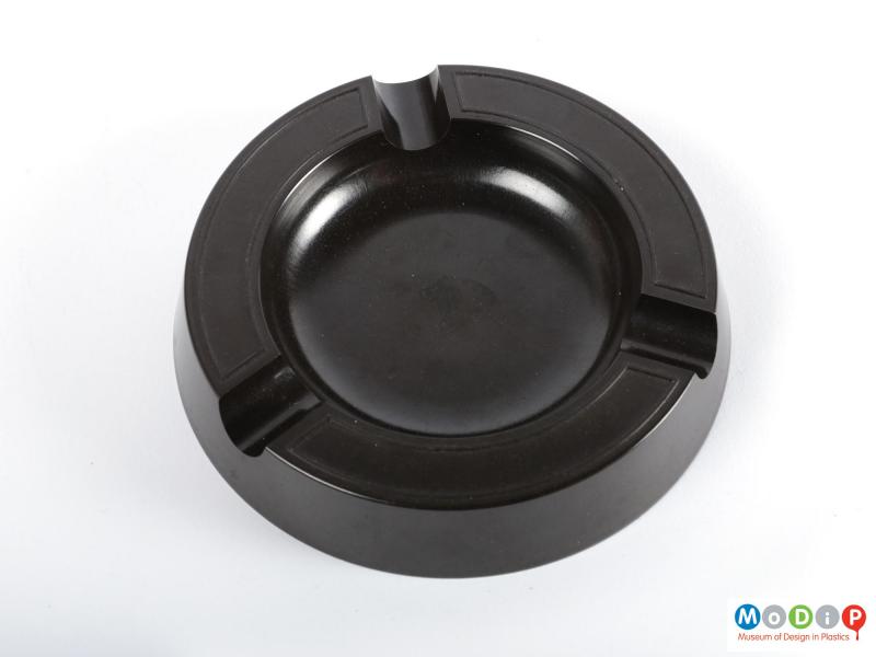 Top view of an ashtray showing the moulded cigarette rests and simple decoration.