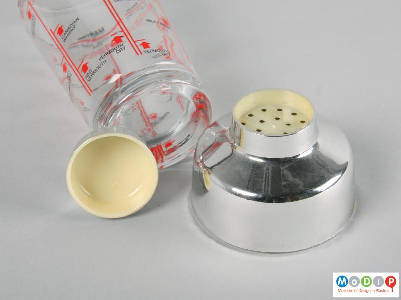 Close view of a cocktail shaker showing the strainer and cover.