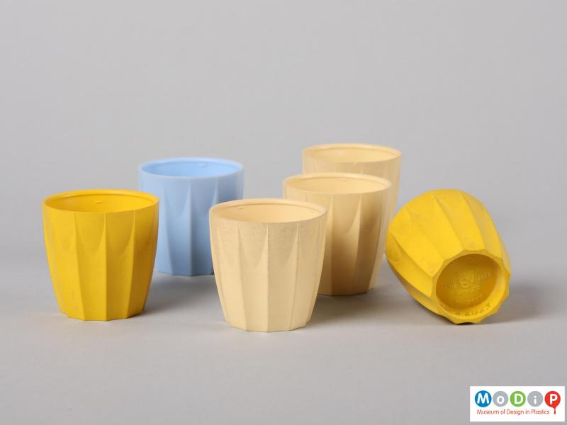 Side view of six nBware egg cups showing the distinct moulded ribbing down the side of the cups.  One cup is on its side to reveal the underside.