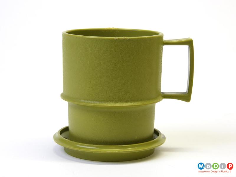 Side view of a mug showing the lid used as a coaster.