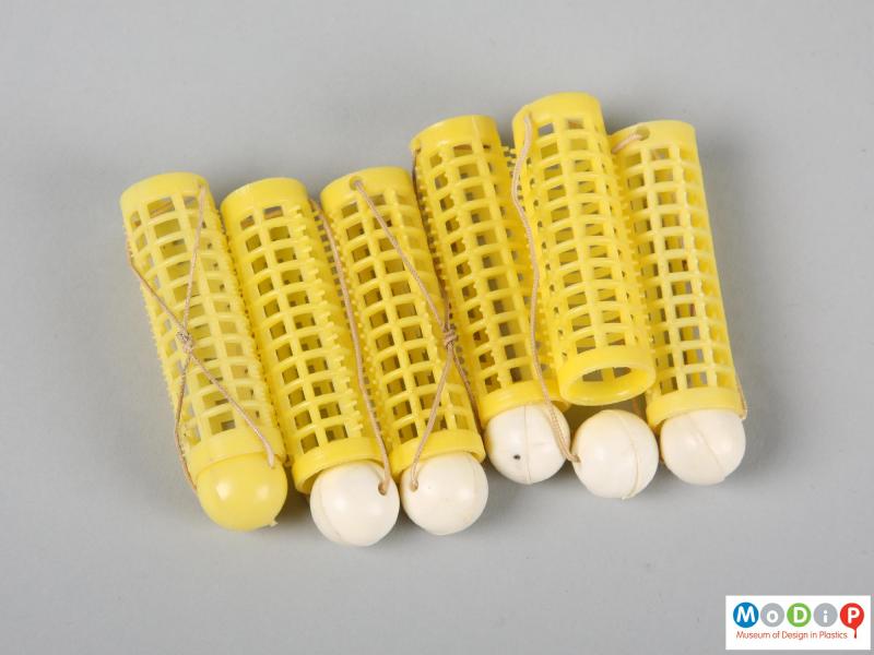 Side view of a set of curlers showing 6 yellow curlers.