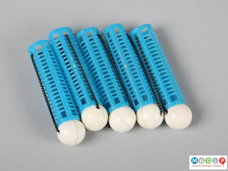 Side view of a set of curlers showing 5 blue curlers.