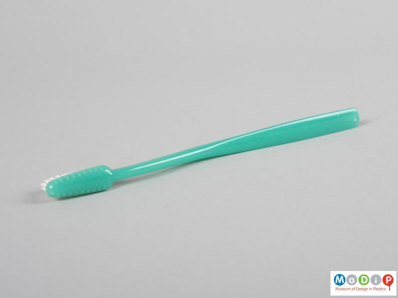 Side view of a toothbrush showing the smooth surface of the material.