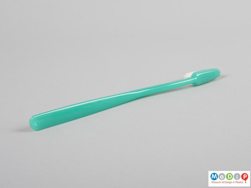 Side view of a toothbrush showing the smooth surface of the material.