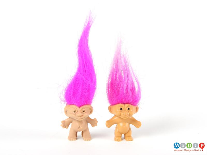 Front view of 2 trolls showing the long pink hair.