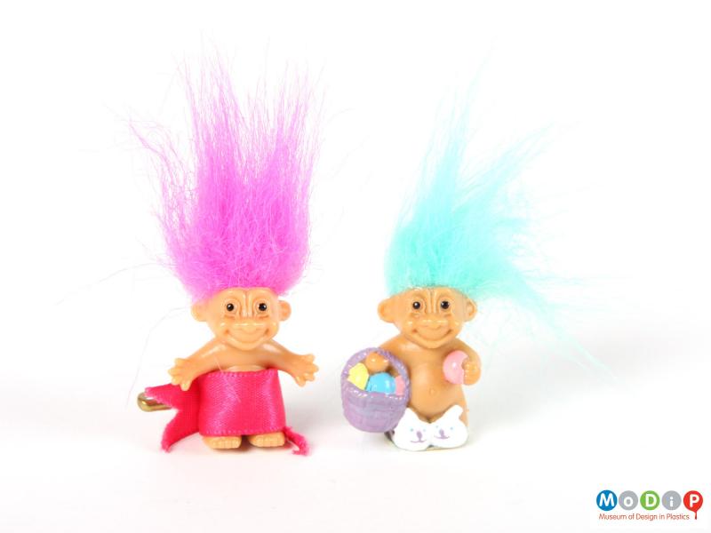 Front view of 2 trolls showing 1 with pink hair and the other with light blue hair.