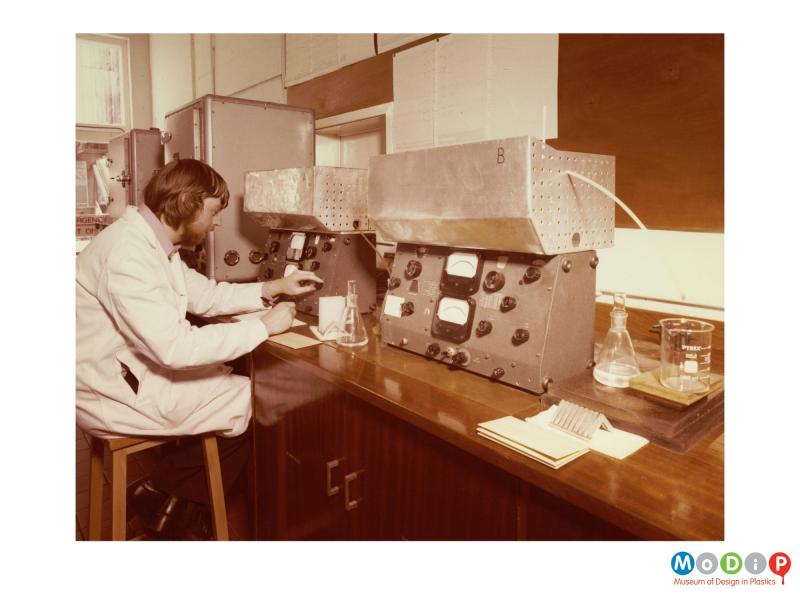 Scanned image showing a man using laboratory equipment.
