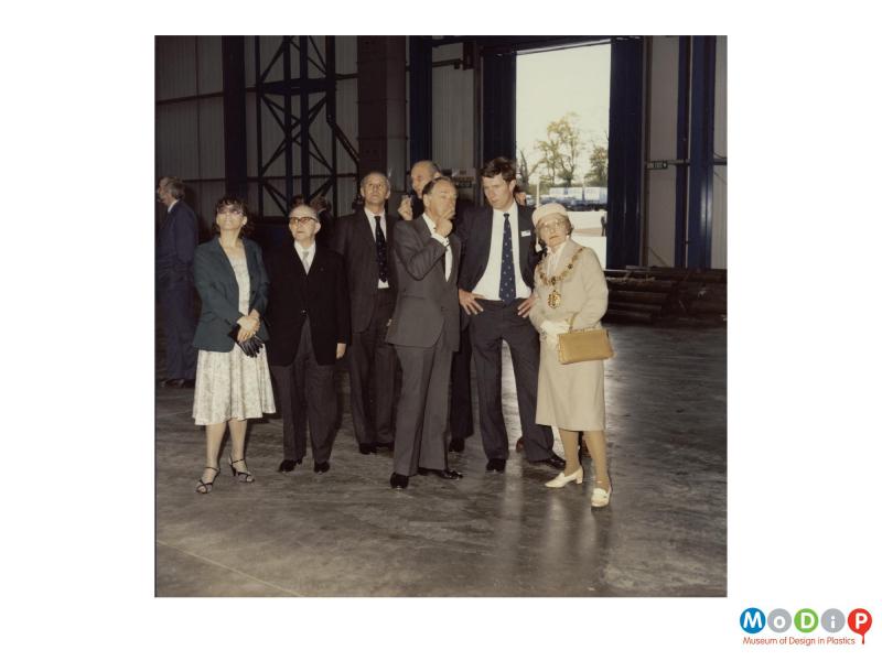 Scanned image showing a group of people at the opening of a new factory.