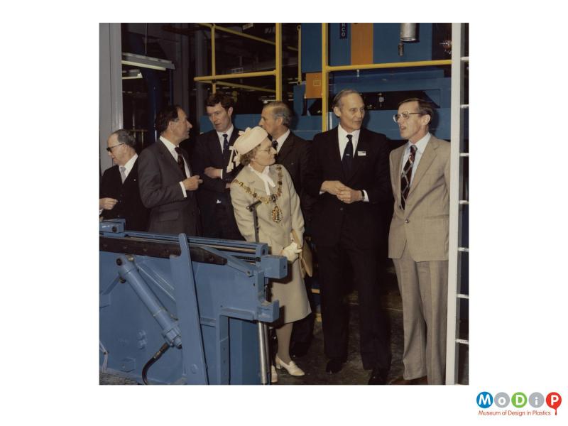 Scanned image showing a group of people at the opening of a new factory.