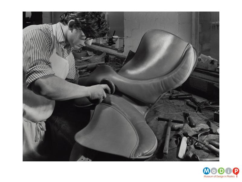 Scanned image showing a man making a horse saddle.