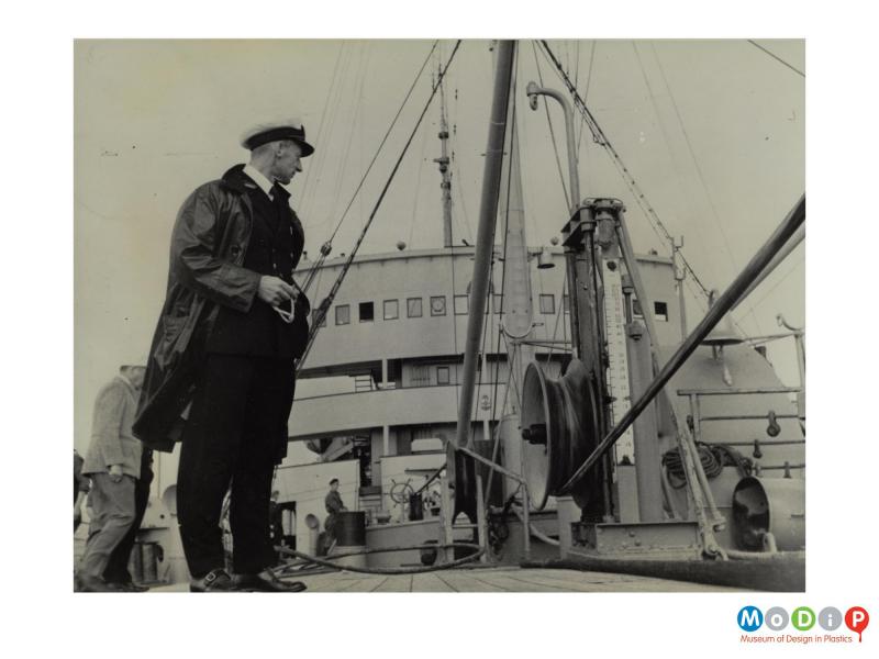 Scanned image showing cable being laid from a boat.