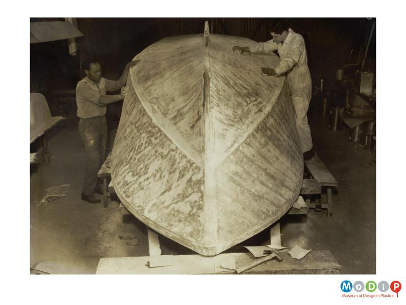 Scanned image showing a boat being made.