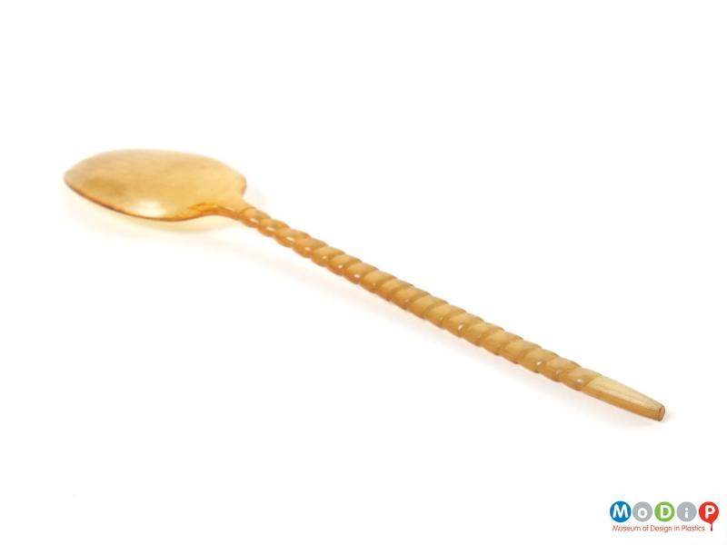 Side view of a spoon showing the carved handle and depth of the bowl.