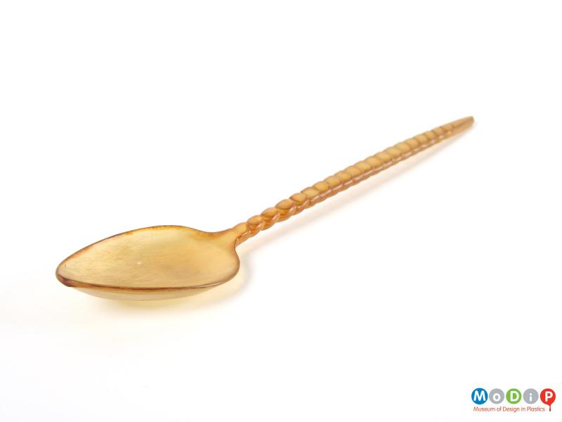 Side view of a spoon showing the carved handle and depth of the bowl.