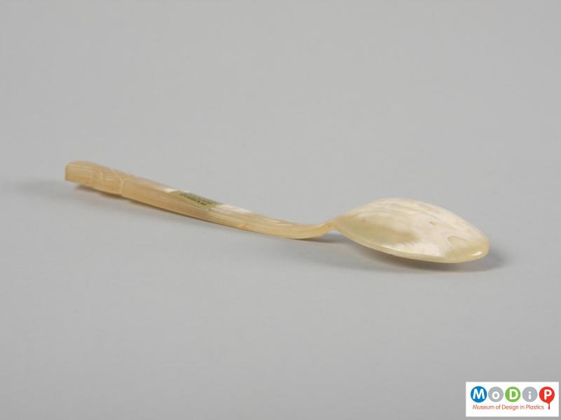 Side view of a spoon showing the straight handle and depth of the bowl.