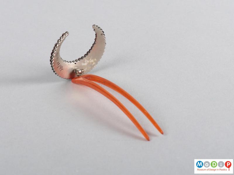 Side view of a hairpin showing the crescent embellishment and two teeth.
