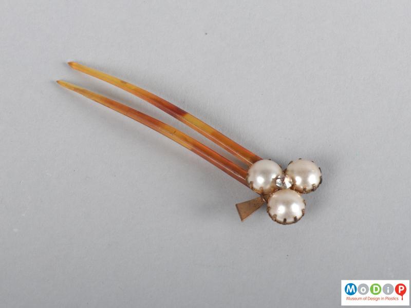 Top view of a hairpin showing the beaded top and two teeth.