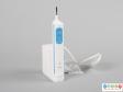 Front view of an electric toothbrush showing the body sitting on the charging unit.