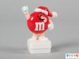 Front view of a red M&M figure showing the smiling face and the limbs.