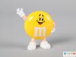 Front view of a yellow M&M figure showing the smiling face and the limbs.