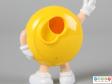 Close view of a yellow M&M figure showing the back plate open.