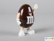 Side view of a brown M&M figure showing the smiling face and the limbs.