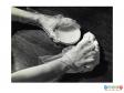 Scanned image showing a pair of hands wearing gloves whilst polishing a piece of wooden furniture.