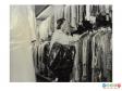 Scanned image showing covered garments in a stockroom.