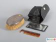 Top view of a grooming set showing the brush, comb, mirror and pouch.