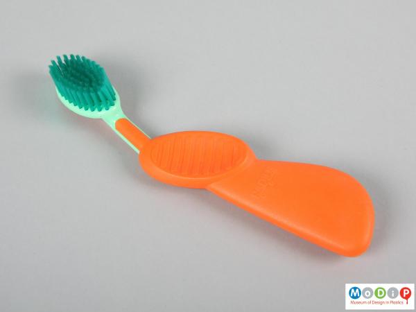Top view of a toothbrush showing the large handle and thumb recess.