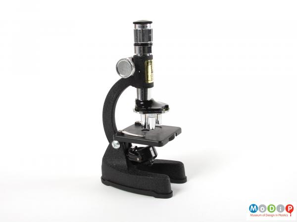 Side view of a microscope showing the adjustable stand and eyepiece.