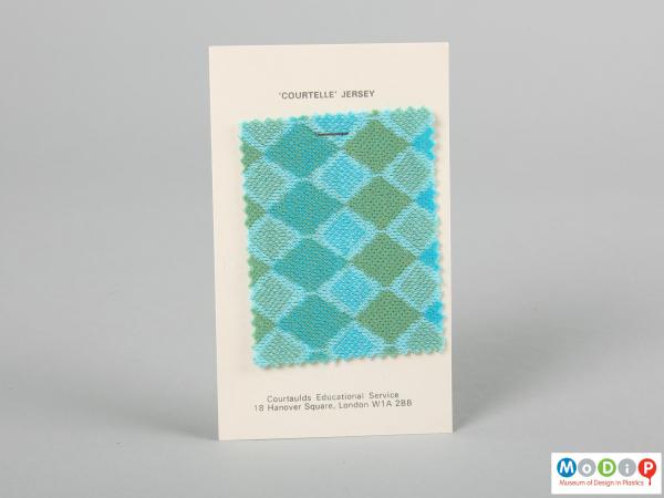 Front view of a fabric sample card showing the material stapled to the card.