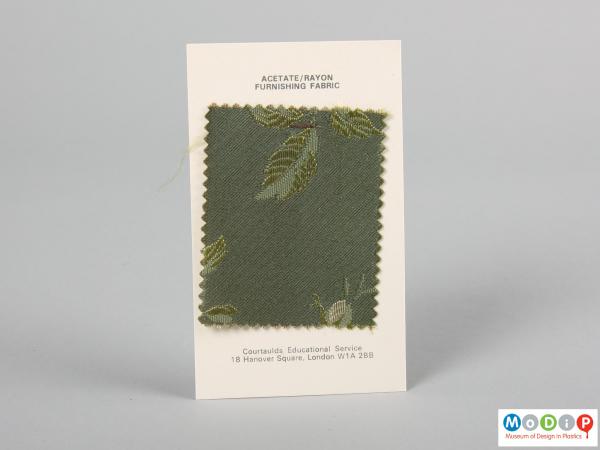 Front view of a fabric sample card showing the material stapled to the card.